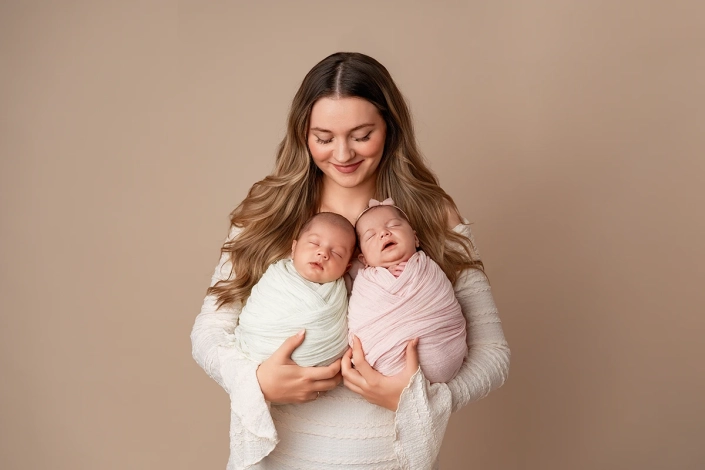 stolze Mama mit ihren Zwillingen im Arm beim Fotoshooting