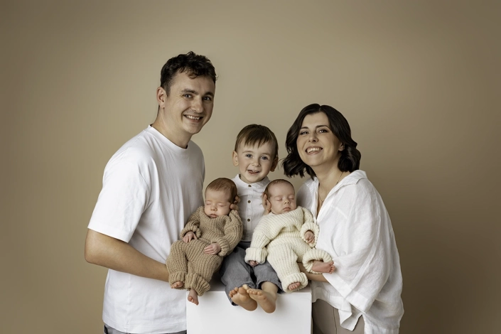 neugeborenenshooting_zwillinge_hamburg Familienportrait von stolzen eltern einen Kleinkind und neugeborenen Zwillingen