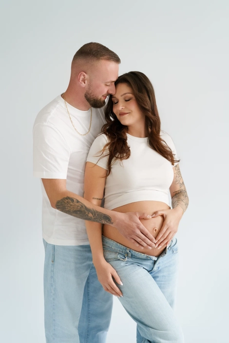 Babybauchshooting-hamburg-natuerlich-jeans Babybauchfotoshooting von einem Paar in Jeans im Tageslichtstudio, Herz auf dem Bauch mit Händen