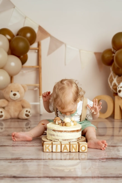 Ein kleiner Junge beißt in die Toerte rein bei seinem Cake smash Fotoshooting