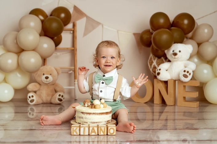 Einjähriger Junge sitzt vor einer Torte bei seinem Cake Smash Fotoshooting