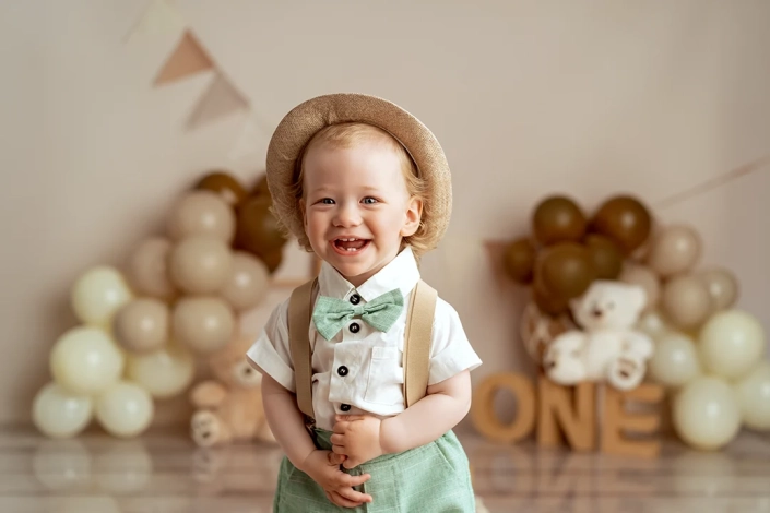 Fröhliches Portrait von einem Einjährigen Jungen im Hut bei seinem Cake smash Fotoshooting